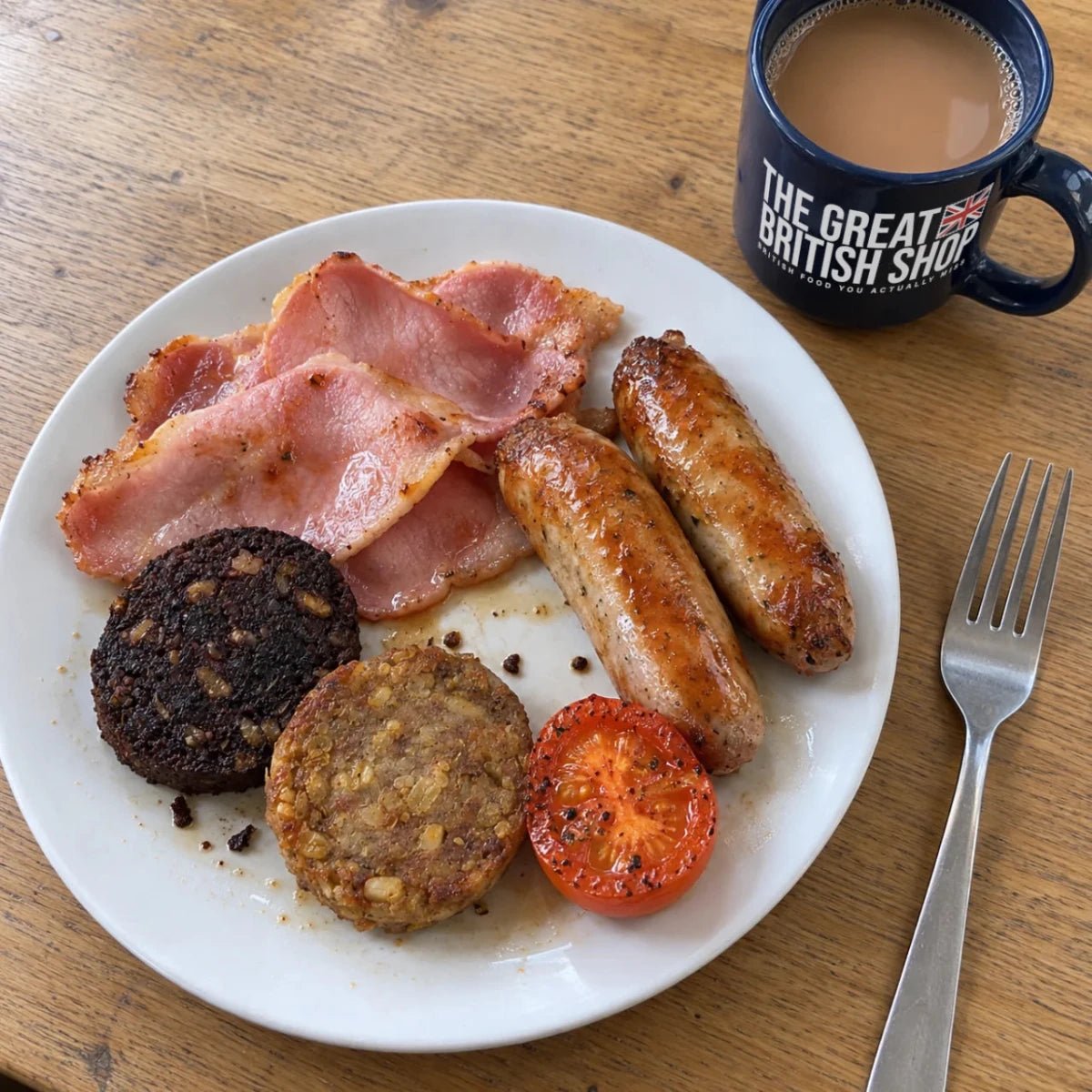 Full British breakfast with bacon, sausages, black pudding, haggis, tomato and tea